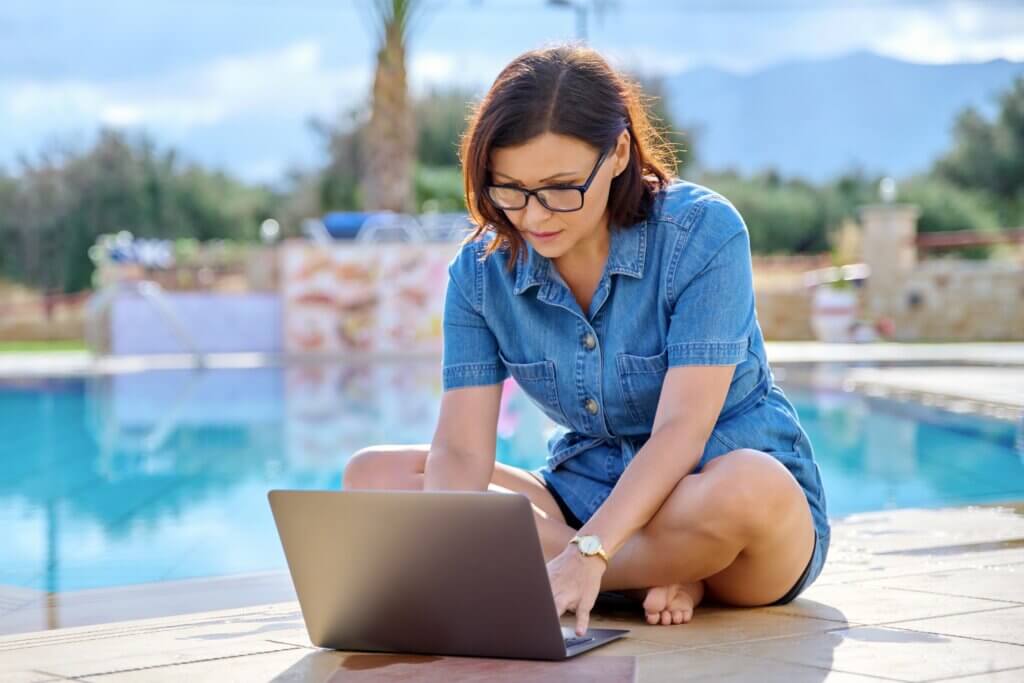 Poslovna žena radi na laptopu pored bazena